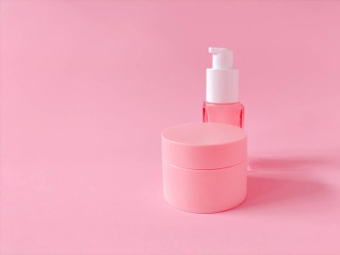 Katı pembe arka planda cilt ürünleri.