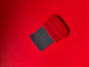 Canlı kırmızı desenli arkaplanda bir pire tarağı.