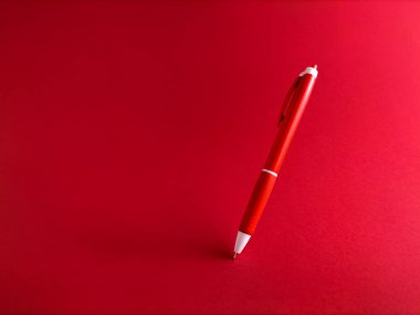 Beyaz bir yüzeyde kırmızı tükenmez kalem.