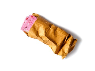 Görünür katları ve kırışıklıkları olan buruşmuş kahverengi bir zarf Endonezya rupia banknotları içerir.