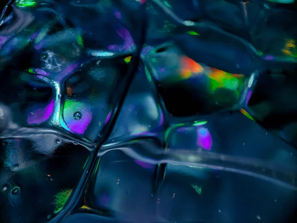 Pürüzsüz dokusunu ve yansıtıcı özelliklerini gösteren mavi cam bir yüzeye yakın plan..