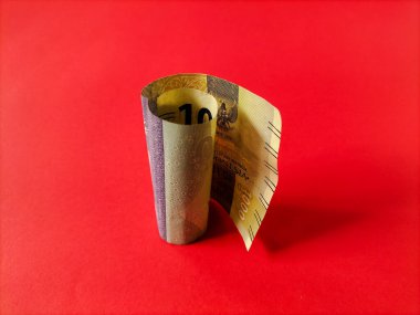 Endonezya 'nın 1000 rupilik banknotu kırmızı arka planda dimdik duruyor..