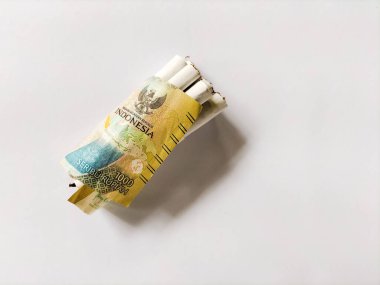 Silindirik sigaralar, Endonezya 'nın 1000 rupia banknotuyla paketlenir..
