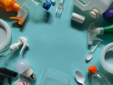 Mavi bir yüzeye yerleştirilmiş plastik atık eşyalar. Geri dönüşüm konsepti plastik atıkların yönetilmesine odaklandı.