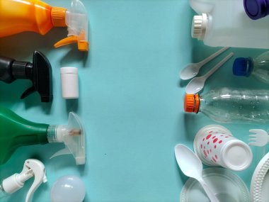 Mavi bir yüzeye yerleştirilmiş plastik atık eşyalar. Geri dönüşüm konsepti plastik atıkların yönetilmesine odaklandı.