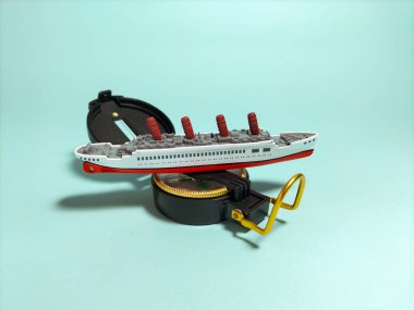 Minyatür yolcu gemisi modeli açık bir pusula üzerinde duruyor..