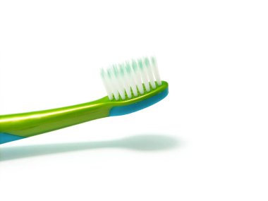 Küçük kafalı mavi ve yeşil plastik saplı çocukların diş fırçası..