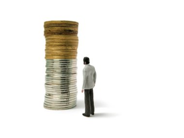 Beyaz arka planda izole edilmiş madeni paraların üzerinde duran minyatür işadamı