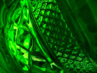 Soyut yeşil cam arka plan, dokulu geometrik şekiller içeriyor..