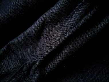 Örgü desenini vurgulayan siyah kumaşın yakın çekimi.