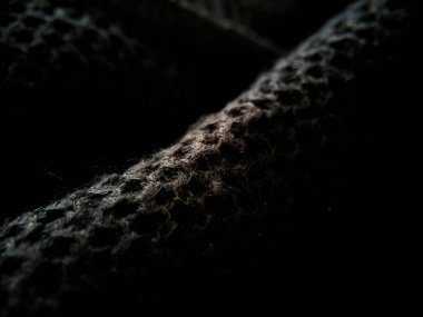 Kalıplı siyah kumaşın yakın plan görüntüsü hafif yansıtıcı yüzeyi olan bir dokuma deseni sergiliyor..