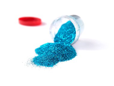 Küçük, şeffaf bir plastik kap beyaz bir yüzeye konur ve parlak mavi bir parıltı saçar..