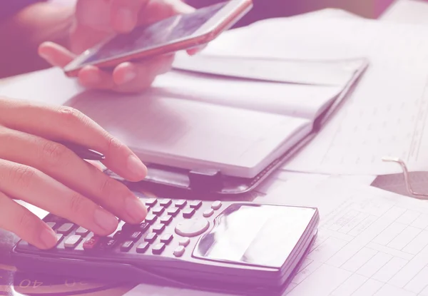 Savings, finances, economy and home concept - close up of man with calculator counting making notes and holding phone,use mobile phone for searching data in office or home, soft focus. — Stock Photo, Image