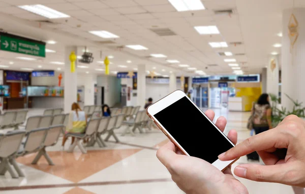 Pantalla humana en blanco de teléfono inteligente y desenfoque de fondo de llegadas de espera . — Foto de Stock