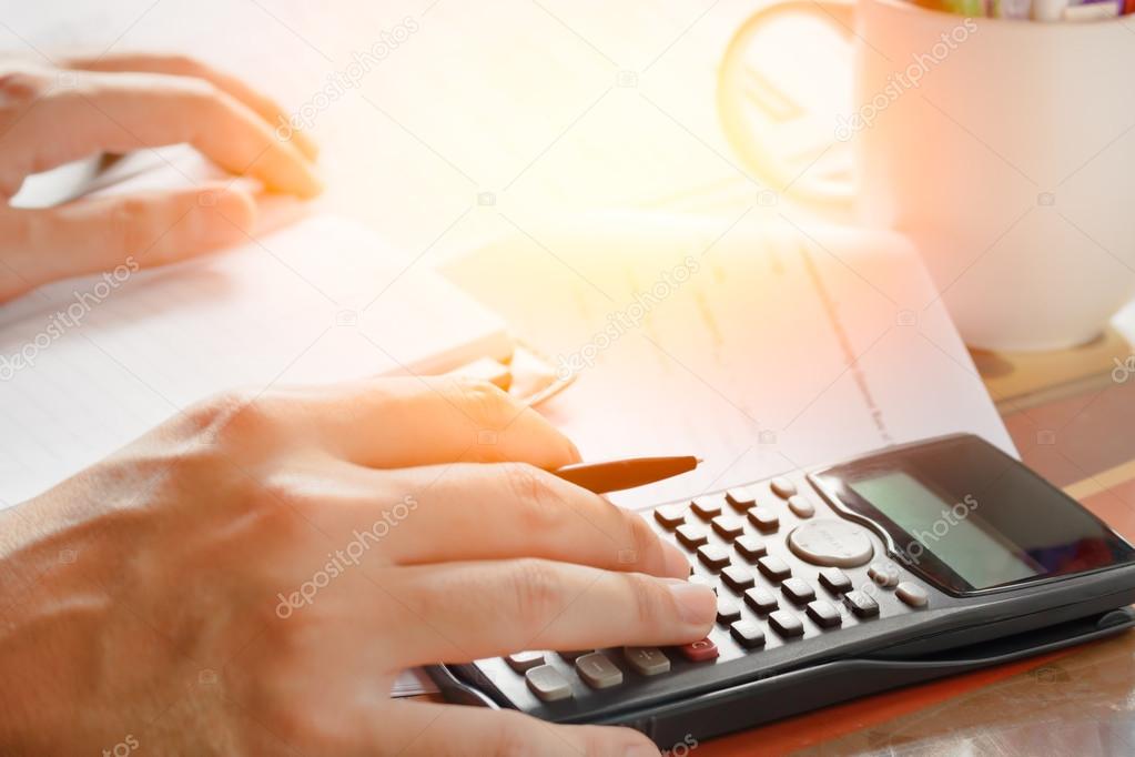 savings, finances, economy and home concept - close up of man with calculator counting making notes at home, soft focus.