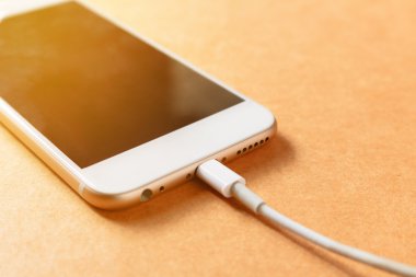 Akıllı telefon ahşap tahta üzerinde güç bankası ile şarj, yumuşak odak.