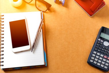 Not defteri, kalem, cep telefonu, hesap makinesi, gözlük ve ofis malzemeleri, gadget'lar, kopyalama alanı, yumuşak odak ile ofis masasının genel müdürü.