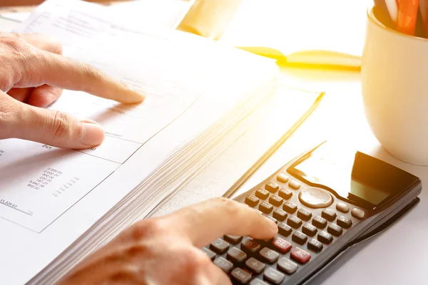 Finansal veri analizi. tasarruf, finans, ekonomi. Ofiste ya da evde hesap makinesi ne sayan bir işadamının elinin yakın çekim fotoğrafı. Yumuşak odaklama