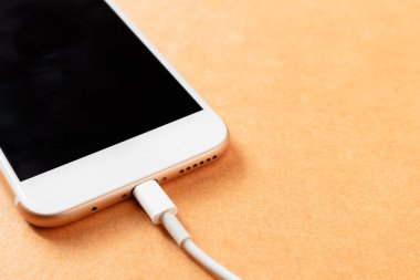 Akıllı telefon ahşap tahta üzerinde güç bankası ile şarj, yumuşak odak.
