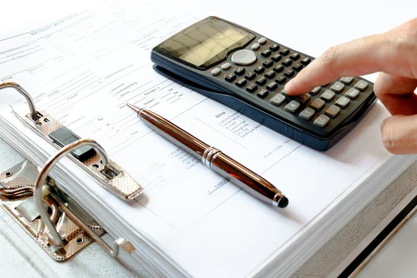 Close up of man with calculator counting making notes, pen on the file folder, data analysis. — Stock Photo, Image