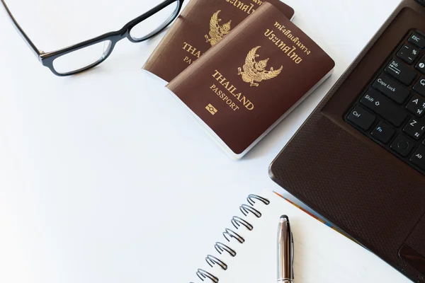 Podróże akcesoria kostiumy. Paszporty Tajlandia, przygotowanie do podróży, Notebook pióra na górze, okulary i laptop lub komputer w czasie wakacji, nieostrość. — Zdjęcie stockowe