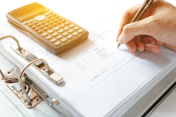 Primer plano de un hombre de negocios que analiza el documento de contabilidad de la nota de escritura con la calculadora en el escritorio en la oficina. enfoque suave . — Foto de Stock