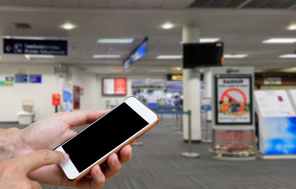 人間がスマートフォンの空白画面を保持し、出発を待っている時間の背景ぼかし. — ストック写真
