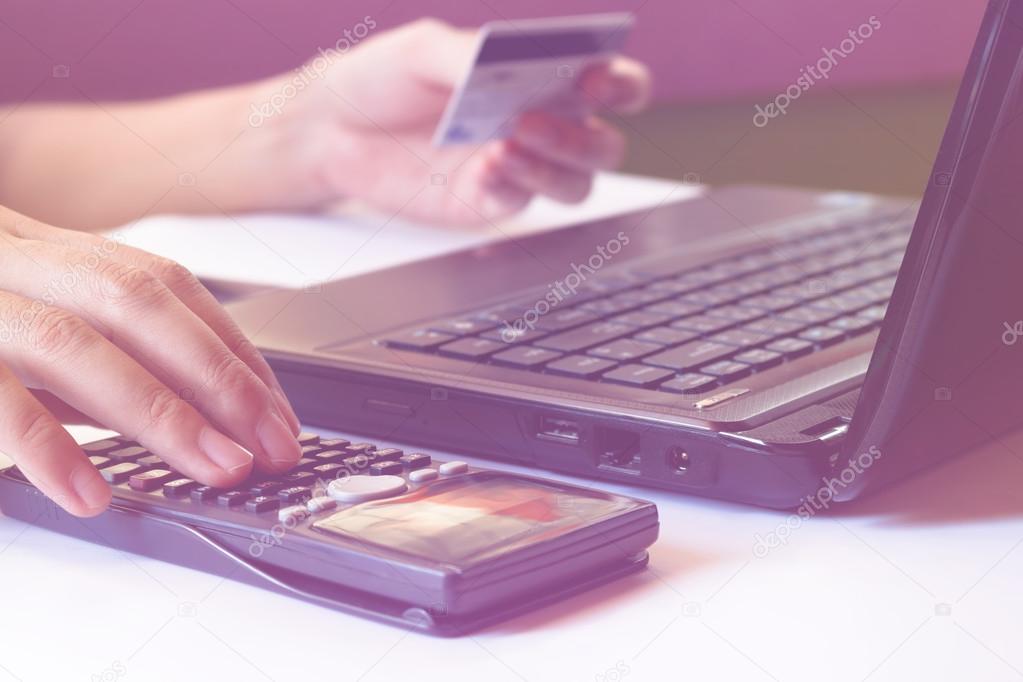 savings, finances, economy and office concept, calculate how much cost or spending have with credit cards. Low light,  can be used for e-commerce, laptop, business, technology and internet concept, soft focus.