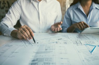 Mühendislik işçisi, ev satın alanların ayrıntılı planlarını gösteriyor..