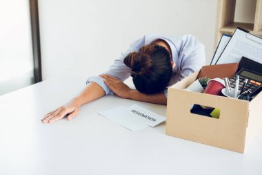 Kadın çalışan, şirketten istifa etmek için aldığı sözleşme zarfını aldığında masasında üzgün hissediyordu..