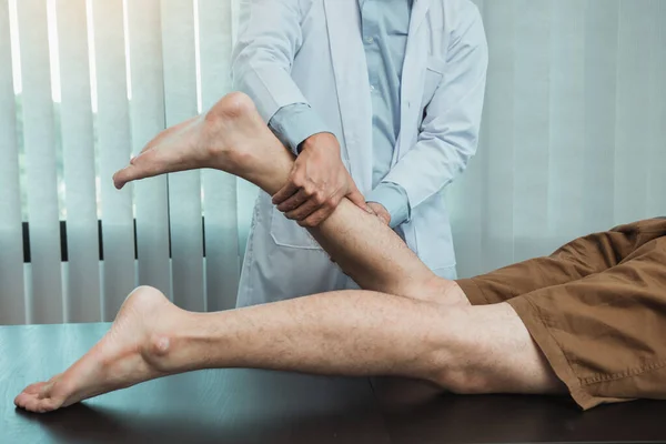 Terapis Fisik Menggunakan Tangan Mereka Untuk Memeriksa Otot Betis — Stok Foto
