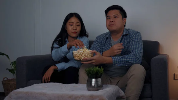 Asian couples watch movies on TV on weekends at night.