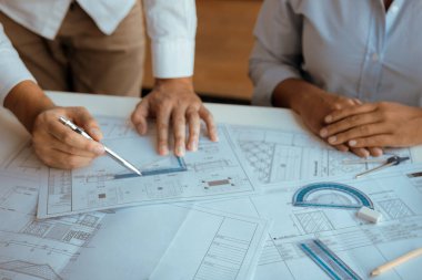 Mimarlar, planlarla çalışan ve ofiste projeyi tartışan mühendisler..