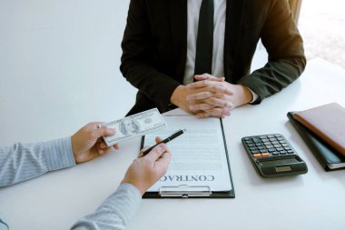 Ortak, satış sözleşmesinde bir sahtekarlık yaptı ve iş adamına rüşvet konseptini imzalayan bir para ve kalem uzattı..