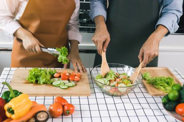 Asyalı çift mutfakta sebze salatası pişiriyor..