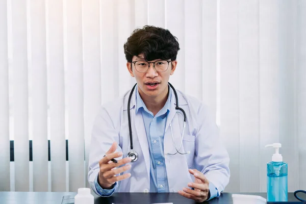 Médico Asiático Que Usa Anteojos Uniformes Blancos Con Estetoscopio Proporciona —  Fotos de Stock