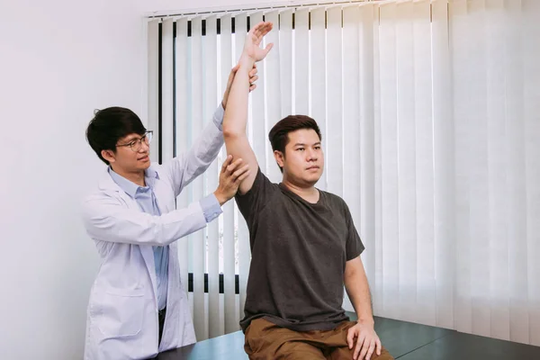 Chiropractor Stretching Een Jonge Man Arm Het Medisch Kantoor — Stockfoto