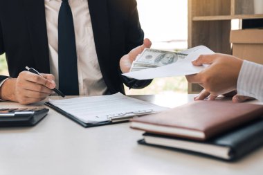 Girişimciler dolandırıcılıkla ilgili bir sözleşme imzalarken, meslektaşlar zarf içinde para veriyor..
