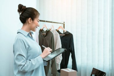 Genç Asyalı girişimciler online satın alma siparişlerini kontrol ederken bir tablet kullanıyorlar.