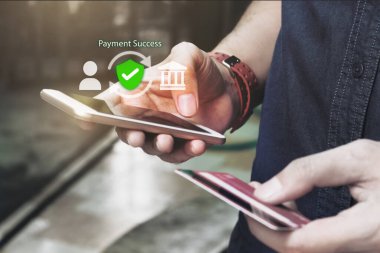 Çevrimiçi güvenlik ödeme konsepti. Adam akıllı telefon kullanıyor ve internetten alışveriş kartı tutuyor..