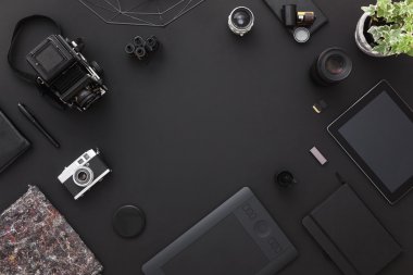 Yaratıcı bir tasarımcının çalışma masası üzerinde çalışma alanı veya tabletli bir fotoğrafçı, kameralar diğer ilham verici nesneler ve kopyalama alanı. Teknoloji trendlerinin stüdyo konsepti.