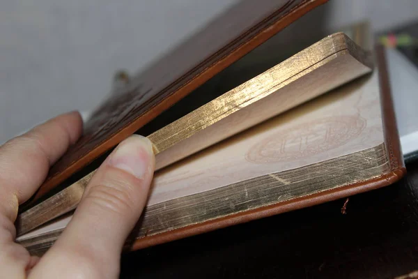 Altın sayfaları olan bir kitabı açan bir elin yakın çekimi