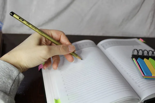 Renkli Yapışkan Notları olan Bir Planlayıcı ile El Yazımı