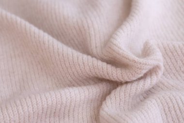 Örülmüş pastel pembe süveter dokusu, yakın çekim bej pembe örgü kumaş dokusu.