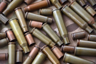 Eski kamuflaj kumaşına isabet eden tüfek mermilerinden çıkan büyük miktarda mermi kovanı. Savaş ve askeri kavram