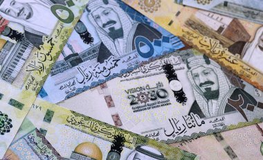 Suudi riyal para faturaları masaya yığıldı. Suudi Arabistan 'ın SAR para birimi banknotları yakın plan. Suudi Arabistan 'da iş, ekonomi ve yatırım kavramı.