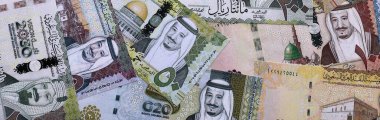 Suudi riyal para faturaları masaya yığıldı. Suudi Arabistan 'ın SAR para birimi banknotları yakın plan. Suudi Arabistan 'da iş, ekonomi ve yatırım kavramı.
