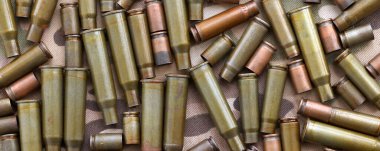 Eski kamuflaj kumaşına isabet eden tüfek mermilerinden çıkan büyük miktarda mermi kovanı. Savaş ve askeri kavram