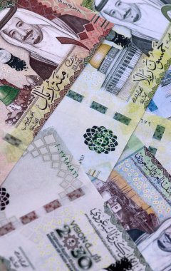 Suudi riyal para faturaları masaya yığıldı. Suudi Arabistan 'ın SAR para birimi banknotları yakın plan. Suudi Arabistan 'da iş, ekonomi ve yatırım kavramı.