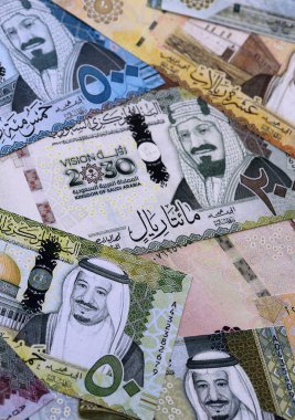 Suudi riyal para faturaları masaya yığıldı. Suudi Arabistan 'ın SAR para birimi banknotları yakın plan. Suudi Arabistan 'da iş, ekonomi ve yatırım kavramı.